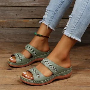 Vue détaillée de sandales compensées vert sauge pour femmes avec motifs ajourés sur les pieds