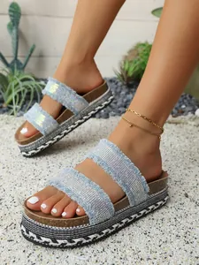 Nahaufnahme von Damen Plateau-Sandalen aus blauem Denim mit Strass und geflochtener Sohle