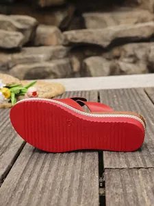 Close-up detail of the red anti-slip rubber sole on these stylish women's wedge sandals.