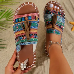 Bohemian flat beach sandals with colorful ethnic patterns and brown tassel detail.