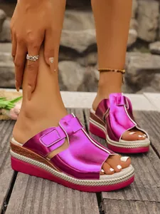 Detailed macro view of metallic purple wedge platform sandals worn on outdoor wooden deck