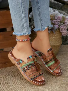 Detailed view of Bohemian flat sandals with ethnic patterns and tassels for summer.