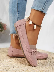 Vue latérale détaillée de mocassins roses en daim pour femmes avec des franges