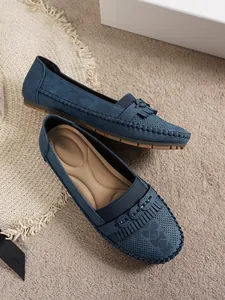 Gros plan de mocassins bleus pour femmes avec glands à franges et motif perforé