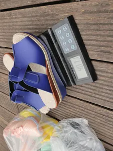 Blue wedge sandal weighed on a digital scale showing 407.1 grams for shipping weight