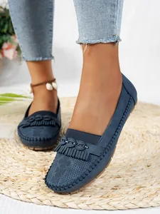 Vue détaillée de mocassins bleus perforés avec franges élégantes et coutures artisanales