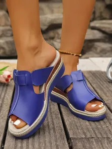Detailed close-up of blue wedge sandals with hollow-out upper and braided platform