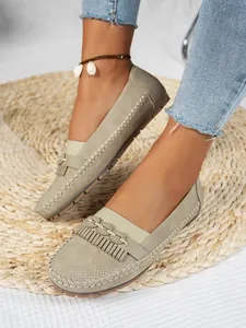 Détail de mocassins plats pour femmes en cuir perforé avec des touches de franges.