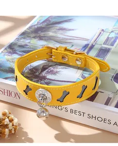 Close-up detail of yellow pet collar with bone-shaped cutouts and a silver bell charm