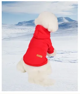 Detail of red fleece dog hoodie with leather 'FASHION' patch in snowy mountain