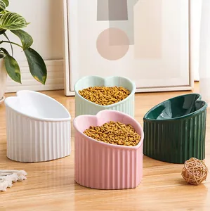 Multiple colorful ceramic heart-shaped pet bowls with slanted opening for neck protection