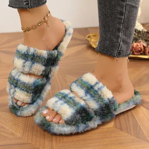 Primer plano de zapatillas de felpa a cuadros azules con dos tiras y pelo sintético