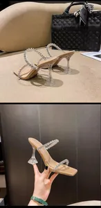 Detail von eleganten High-Heel-Sandalen mit klaren Weinglasabsätzen und Strassriemen.
