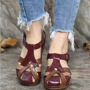 Close-up detail of retro wedge Roman sandals featuring multi-color braided cross straps