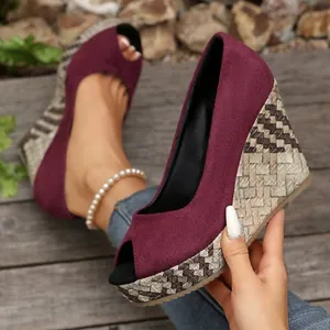 Nahaufnahme weinroter Wildleder-Wedges mit Peep-Toe und modischem Flecht-Plateau-Detail.