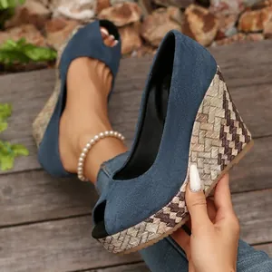 Detail von blauen Peep-Toe-Wedges mit geometrischen Webmustern auf dem Keilabsatz.