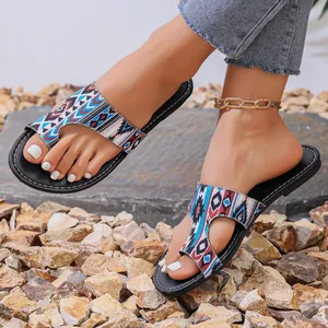 Detailweergave van etnische platte sandalen met tribale print en teenlus voor dames buiten