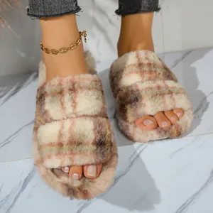 Detalle de zapatillas de felpa a cuadros con dos correas para mujer, textura suave.