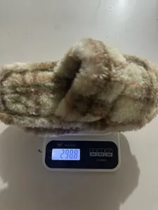 Zapatillas de felpa a cuadros en una báscula digital que muestra el peso en gramos