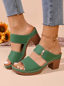 Vue détaillée de mules vertes élégantes à talons épais avec surpiqûres blanches contrastées
