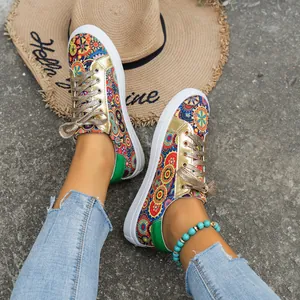 Detailweergave van canvas damessneakers met bohemien bloemenprint en gouden accenten.