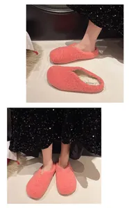 Detailaufnahme von stylischen rosa flauschigen Lammwoll-Hausschuhen mit Paillettenkleid