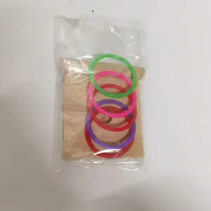 Gedetailleerd overzicht van de papegaaien-trainingsringen en houten basis in een plastic zakje.