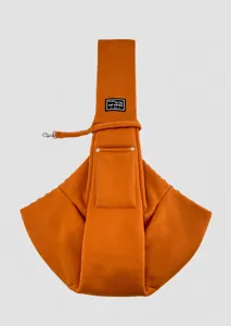 Detail view of the orange pet carrier sling made of soft breathable fabric.