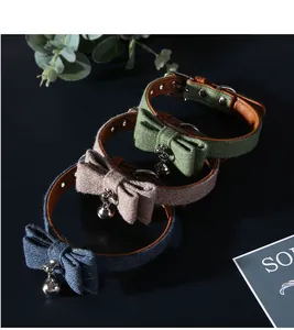 Close-up of felt pet collars with elegant bowties and silver bells in three colors.