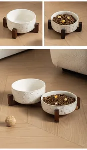 Detailweergave van keramische dierenbakken met pootreliëf op een houten plateau