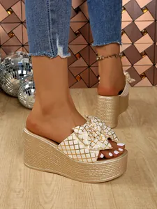 Detail of gold wedge sandals with lattice pattern bow and rope textured platform