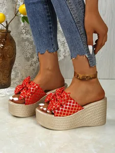 Red checkered platform wedge slides with large bow detail and woven texture