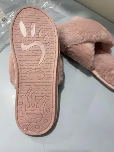 Vue du dessous des chaussons en fausse fourrure rose montrant la semelle.