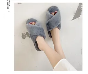Gros plan de chaussons en fausse fourrure grise croisée pour la chaleur intérieure