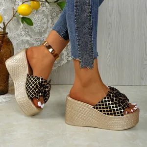 Elegant gold wedge sandals with a decorative bow knot and platform sole for summer fashion.