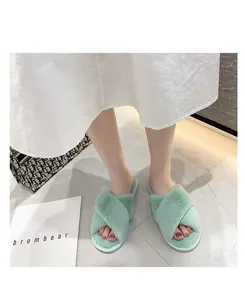 Vue détaillée des chaussons en fausse fourrure vert menthe avec brides croisées