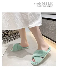 Gros plan de chaussons en fausse fourrure vert menthe à brides croisées