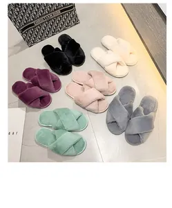 Collection de chaussons en peluche à brides croisées de diverses couleurs pastel sur marbre