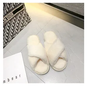 Détail de pantoufles blanches en fausse fourrure à bandes croisées