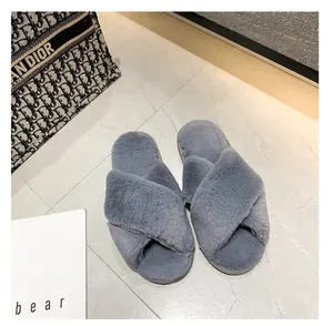 Gros plan de chaussons en fausse fourrure de lapin grise à brides croisées élégantes