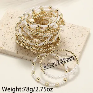 Détail du lot de 5 bracelets avec perles, billes dorées et breloques en croix blanches.