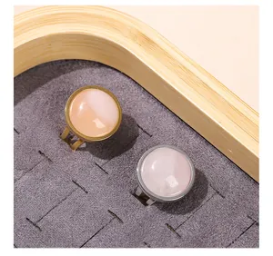 Detail of two titanium steel rings with round pink natural stones in gold and silver finish