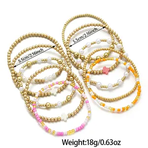 Détail d'un ensemble de 5 bracelets en perles avec breloques croix et perles dorées