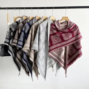 Various colors of paisley pattern triangle shawls hanging on a display rack