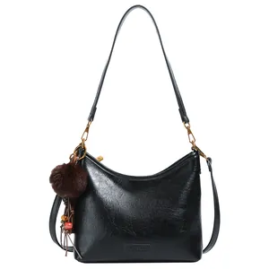 Vintage black faux leather hobo bag with fluffy pompom charm and adjustable strap