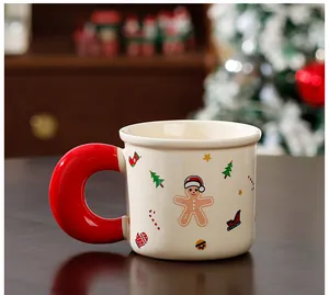 Vue détaillée d'un mug de Noël en céramique avec bonhomme de pain d'épices et anse rouge.