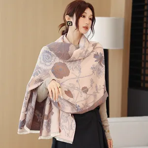 Close-up of elegant faux cashmere shawl with blue ink floral prints and tassel fringe