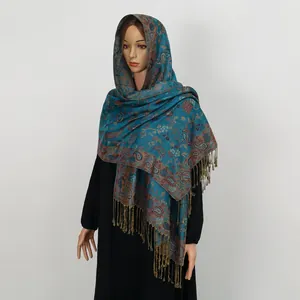 Detailansicht eines Vintage-Schals mit Paisleymuster, Quasten in elegantem Blaugrün.