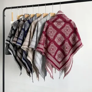 Macro view of multi-colored paisley pattern pashmina shawls with frayed edges on a rack