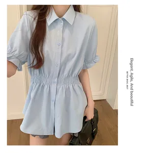 Detail of a light blue short-sleeved shirt with an elegant elastic waist design.
